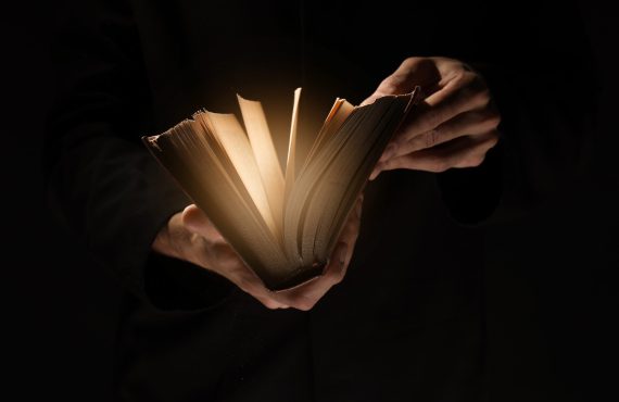 Priest,With,Old,Bible,On,Black,Background,,Closeup